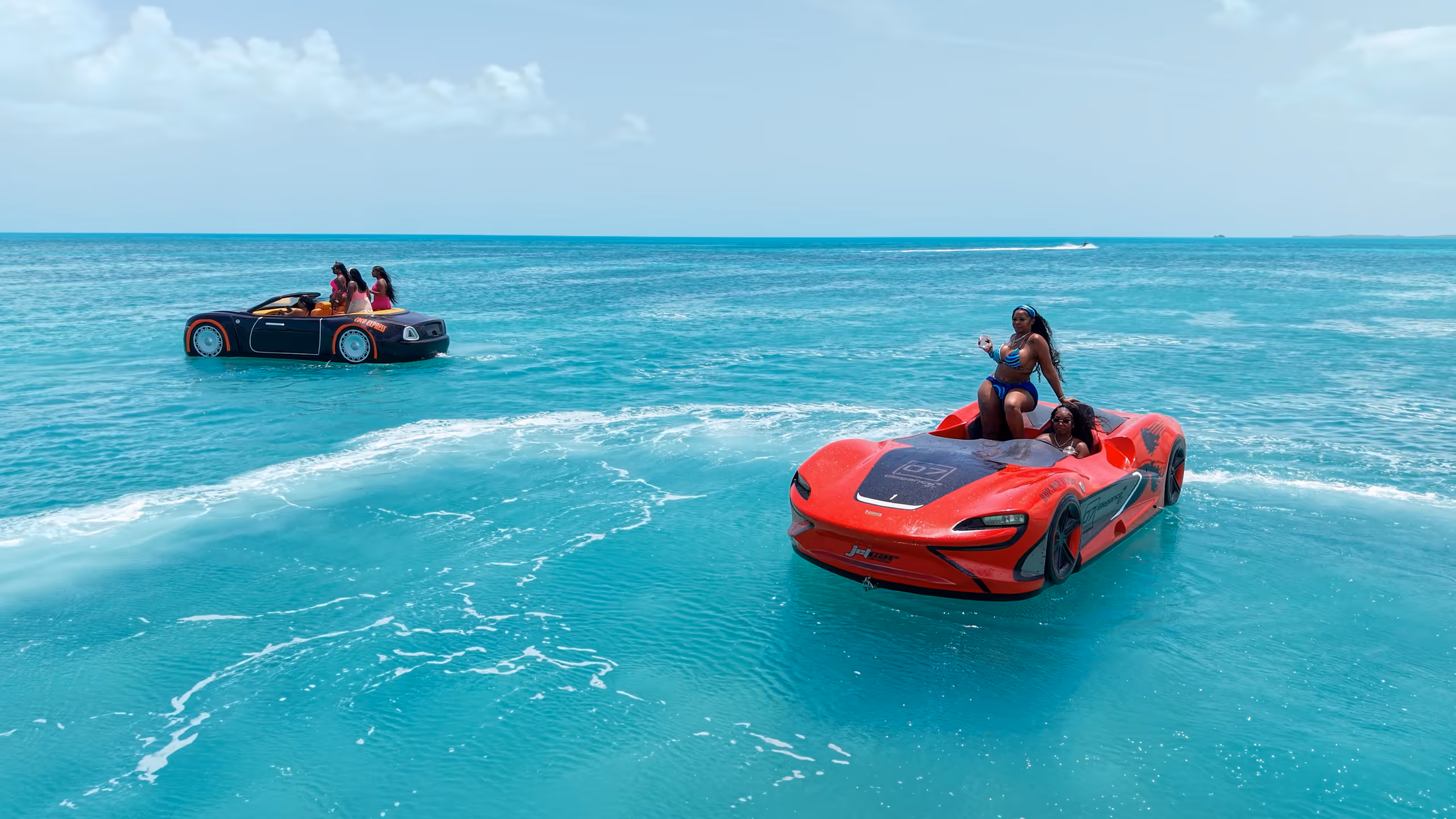The red Jet Car and the black Jet Car on turquoise water, seen from our drone