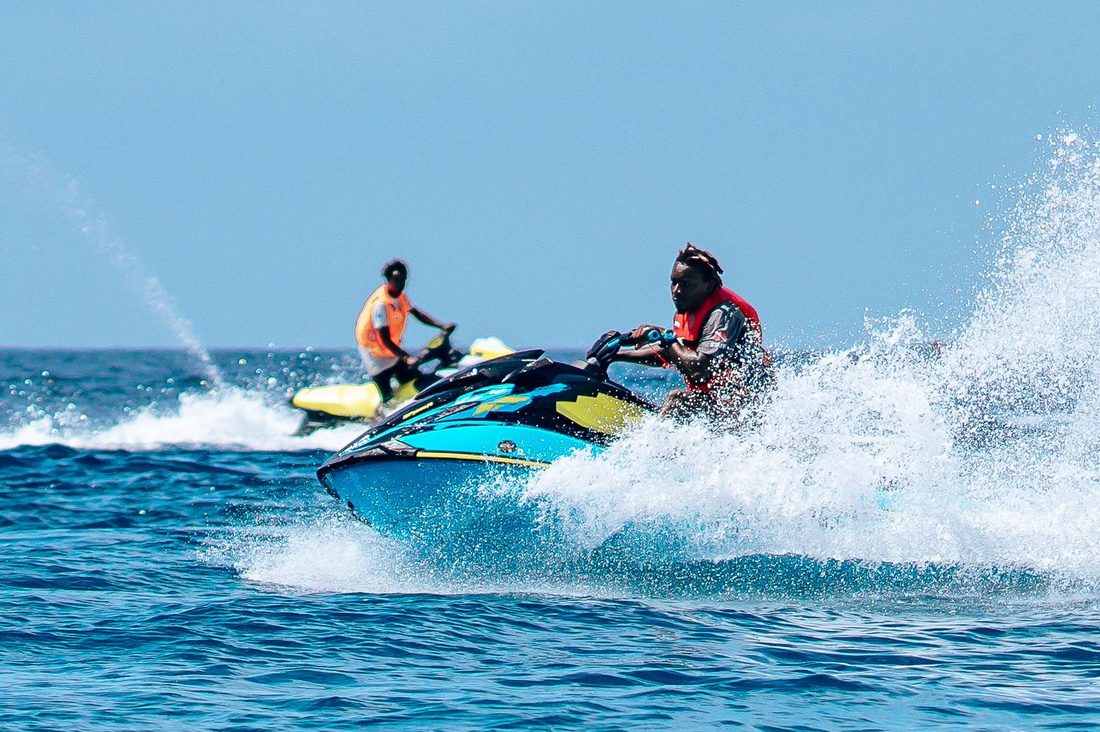 Two Jet Skis riding side by side through open water